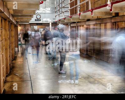 Una lunga vista di un corridoio nello storico Penitenziario Federale di Alcatraz mostra le immagini spettrali delle persone che camminano. Foto Stock