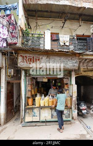 Cliente al di fuori di un piccolo negozio a Paharganj, Delhi, India Foto Stock