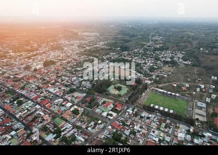 Piccola città con campo da calcio vista aerea drone nelle giornate di sole Foto Stock