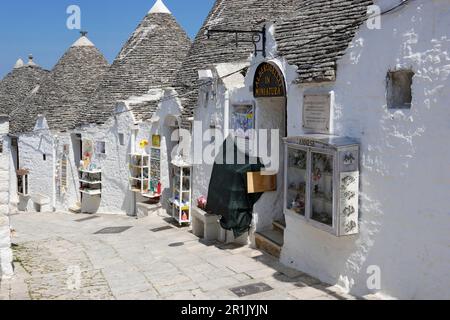 Piccoli negozi e i loro trucchi pubblicitari a Rione Monti, Alberobello, Puglia Foto Stock