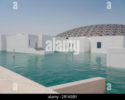 Abu Dhabi, Emirati Arabi Uniti - 21 marzo 2023 : esterno del Louvre, famoso museo di Abu Dhabi. Pareti bianche semplici che circondano un fossato verde smeraldo sormontato da un ornato Foto Stock