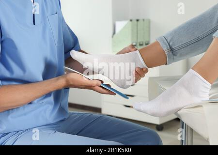 Soletta ortopedica maschile che si adatta al piede del paziente in ospedale, primo piano Foto Stock