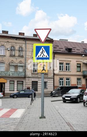 Posta con diverse indicazioni stradali sulla strada cittadina Foto Stock