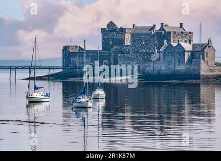 Castello di Blackness al sole vago con barche a vela ormeggiate in acque calme, Firth of Forth, Scozia, Regno Unito Foto Stock