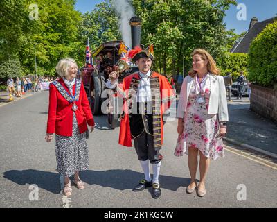 Lymm May Queen e Rose Queen 2023. Lymm Town Crier suona la sua campana per iniziare la processione Foto Stock