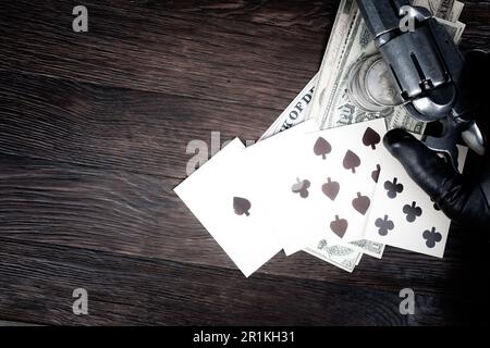 La mano dell'uomo morto. Mano di poker a due coppie composta dagli assi neri e dalle lotte nere e mano del giocatore con revolver. Foto Stock