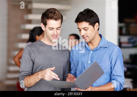 Im è rimasto davvero colpito da queste idee. Due colleghi amichevoli che discutono di un portafoglio aziendale in ufficio. Foto Stock