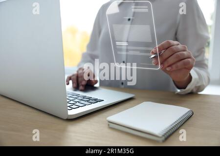 Concetto di firma elettronica. Donna che lavora su un computer portatile al tavolo al chiuso, in primo piano Foto Stock
