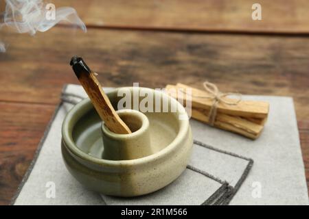 Bastone di palo Santo che frolla in supporto su tavolo di legno Foto Stock