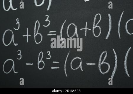 Molte formule matematiche diverse scritte sulla lavagna, primo piano Foto Stock