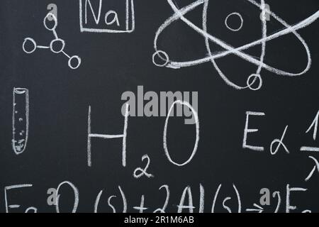 Diverse formule matematiche scritte con il gesso sulla lavagna Foto Stock