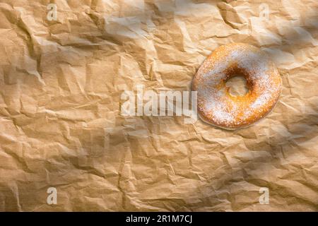 Ciambelle fresche fatte in casa con zucchero in polvere su carta da forno. Concetto di panetteria americana. Foto Stock