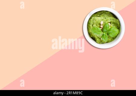 Vista ravvicinata del porridge di spinaci con fagioli di arachidi isolati su sfondo rosa. adatto per alimenti per bambini. Foto Stock