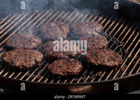 Grigliare hamburger su barbecue barbecue grill su carbone caldo. Hamburger fatti in casa vengono arrostiti al grill bar. Foto Stock