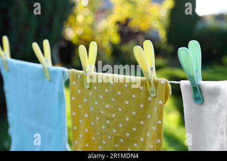 Asciugando i vestiti puliti in giardino, fuoco su clothespin Foto Stock