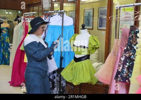 (230515) -- CAIRO, 15 maggio 2023 (Xinhua) -- Una donna visita una mostra di vestiti e accessori durante la prima edizione della settimana della moda egiziana al Cairo, Egitto, 13 maggio 2023. Più di 70 designer egiziani hanno presentato le loro collezioni sulla pista e fuori dalla pista nella prima edizione della Egypt Fashion Week, un evento di quattro giorni che ha avuto inizio venerdì. L'evento, organizzato dal Consiglio egiziano della moda e del design (EFDC) sotto gli auspici del Ministero egiziano della pianificazione e dello sviluppo economico, del Ministero del Turismo e delle Antichità e del Ministero dell'Agricoltura e del recupero del territorio, è Foto Stock