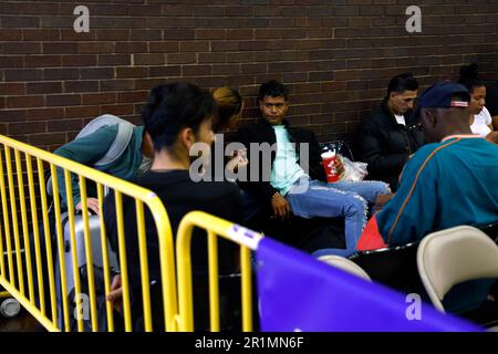 I richiedenti asilo attendono di essere trasferiti tramite autobus urbano dal terminal degli autobus di Port Authority a un impianto di alloggio il 14 maggio 2023 a New York City, USA. Dopo essere arrivati dal confine tra Texas e Messico e dopo essere stati processati dai funzionari di New York City, i migranti vengono inviati a varie strutture abitative nei quartieri di New York. Nei prossimi giorni il Roosevelt Hotel fornirà inizialmente un numero limitato di posti letto e successivamente funterà da centro di accoglienza e supporto per i migranti. (Foto di John Lamparski/Sipa USA) Credit: Sipa USA/Alamy Live News Foto Stock