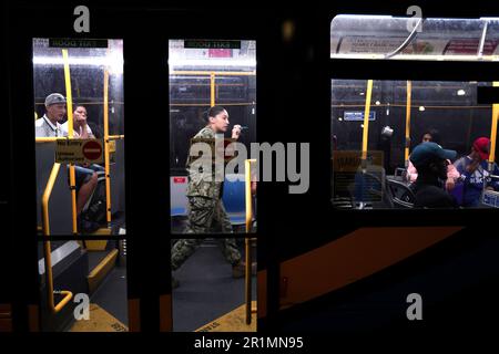 Il personale militare prende un conto in quanto i richiedenti asilo sono trasferiti via autobus urbano dal terminal degli autobus di Port Authority a una struttura abitativa il 14 maggio 2023 a New York City, USA. Dopo essere arrivati dal confine tra Texas e Messico e dopo essere stati processati dai funzionari di New York City, i migranti vengono inviati a varie strutture abitative nei quartieri di New York. Nei prossimi giorni il Roosevelt Hotel fornirà inizialmente un numero limitato di posti letto e successivamente funterà da centro di accoglienza e supporto per i migranti. (Foto di John Lamparski/Sipa USA) Credit: Sipa USA/Alamy Live News Foto Stock