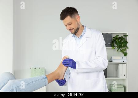 Soletta ortopedica maschile che si adatta al piede del paziente in ospedale Foto Stock