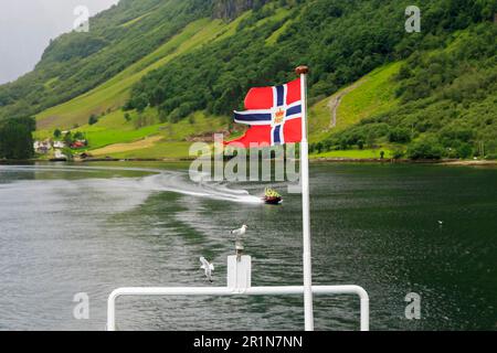 Questa è la bandiera di Posten Norfe sul traghetto di poppa flagstaff che naviga verso Geirangerfjord. Foto Stock