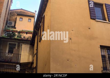 Piccolo balcone con piante in vaso inserito in un vicolo ombreggiato in una città italiana al tramonto Foto Stock