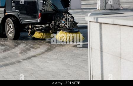 Veicolo per la pulizia stradale. la macchina raccoglie rifiuti, rifiuti e foglie Foto Stock