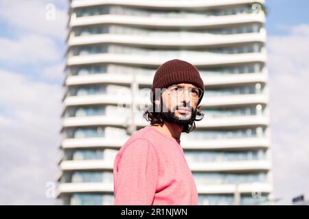 giovane uomo alla moda che cammina la mattina in città Foto Stock