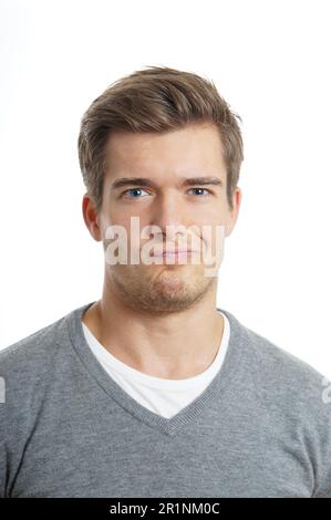Giovane uomo è la realizzazione di un divertente volto Foto Stock