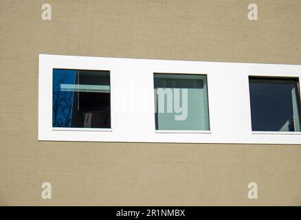 Dettaglio di una parete marrone con finestre bianche Foto Stock