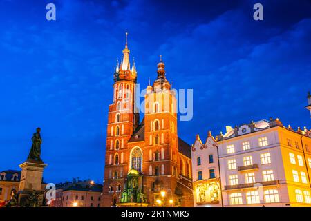 Piazza del Mercato con il Saint Mary's Basilica nella città vecchia di Cracovia in Polonia Foto Stock