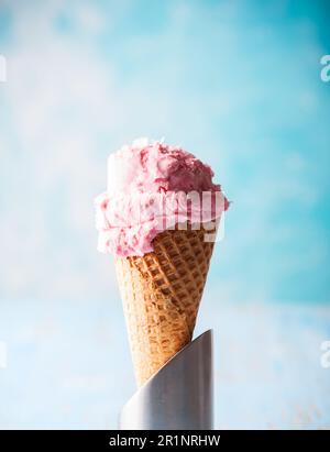 Gelato al lampone in cialda di wafer su fondo blu Foto Stock
