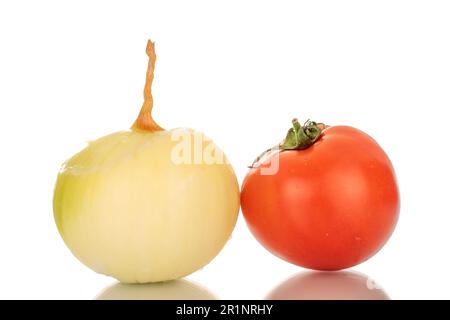 Una cipolla sbucciata e un pomodoro, macro, isolato su fondo bianco. Foto Stock