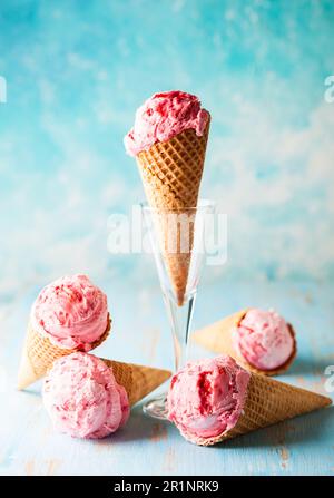 Gelato al lampone in cialda di wafer su fondo blu Foto Stock