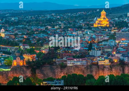 Vista panoramica di Tbilisi, Georgia dopo il tramonto con Sameba, la Cattedrale della Trinità Foto Stock