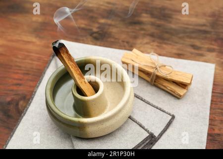 Bastone di palo Santo che frolla in supporto su tavolo di legno Foto Stock