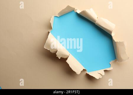 Buco in carta beige su sfondo azzurro, spazio per il testo Foto Stock