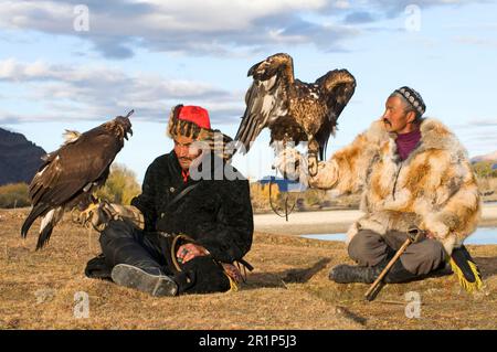 Cacciatori kazaki con aquile d'oro (Aquila chrysaetos), montagne Altai, Bayan-Ulgii, Mongolia occidentale Foto Stock