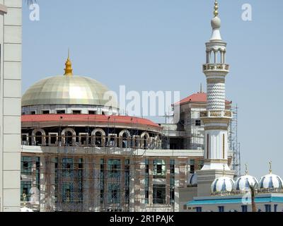 Cairo, Egitto, aprile 26 2023: Una bella moschea bianca nel nuovo Cairo Egitto con più cupole e minareti accanto a un edificio in costruzione con un Foto Stock