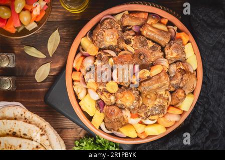 Cucina araba; stufato di coda di bue tradizionale egiziana con verdure. Servito con pane piatto tradizionale e sottaceti. Foto Stock