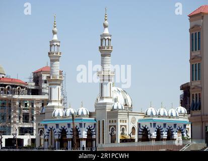 Cairo, Egitto, aprile 26 2023: Una bella moschea bianca nel nuovo Cairo Egitto con più cupole e minareti accanto a un edificio in costruzione con un Foto Stock