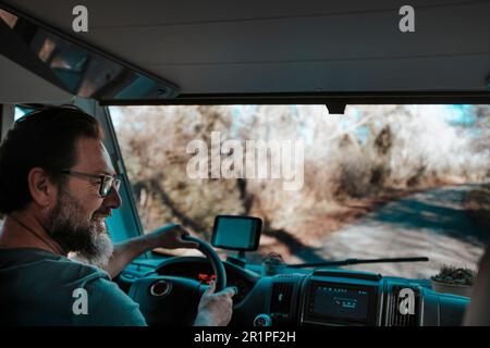 Uomo felice con barba sorridente e camper drive, sistema di navigazione gps. Guardare il passeggero e godersi il viaggio. Motor home caravan vacanza vacanza avventura concetto lifestyle vanlife Foto Stock