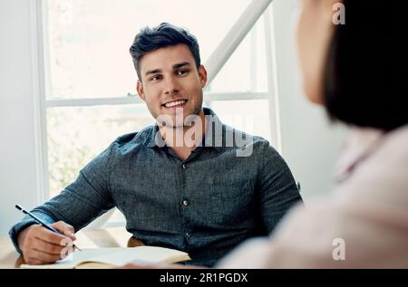 Tutto il resto che ho bisogno di sapere. un bel giovane uomo d'affari seduto con un collega in ufficio durante il giorno. Foto Stock
