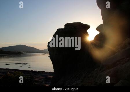 Alba sulla spiaggia vicino Kiotari, roccia retroilluminata, scatto di retroilluminazione, Rodi, Grecia Foto Stock