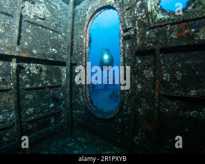 Taucher mit Lampe auf dem Deck der Korvette Afonso Cerqueira vor der Küste Madeira, Schiffswrack für Sporttaucher im Atlantik, Diver con lampada sul Foto Stock