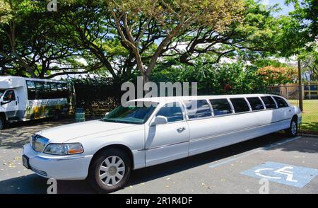 Una limousine bianca parcheggiata presso i Moanalua Gardens accanto a un gruppo di alberi, a Honolulu, Hawaii. Foto Stock