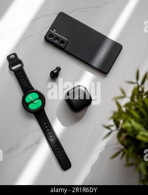 Orologio intelligente, auricolare e smartphone su un tavolo in marmo Foto Stock