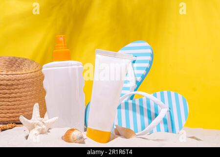 Bottiglie di crema solare sulla spiaggia di sabbia, sfondo giallo elettrico. Sfondo estivo per la salute e la cura della pelle dai colori vivaci, con crema per bottiglie SPF per protezione solare. Foto Stock