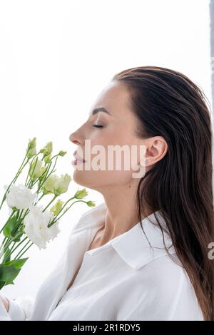 Ritratto di una bella donna che odora un mazzo di fiori Foto Stock