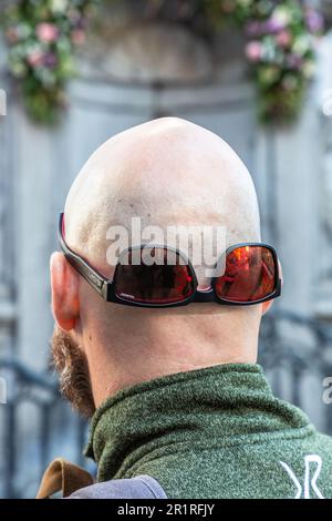 Vista posteriore di una testa calva con occhiali da sole rovesciati. Bruxelles. Foto Stock