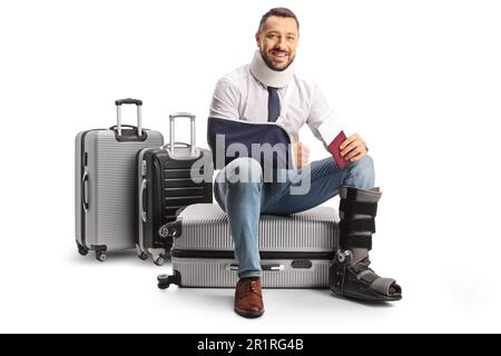 Uomo con braccio rotto e collo cervicale seduto su una valigia e tenendo un passaporto isolato su sfondo bianco Foto Stock